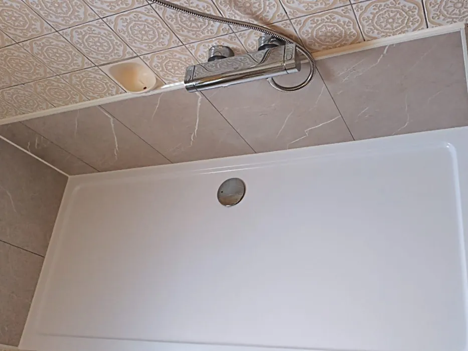 Nachher: flache Duschtasse mit Wandpaneelen in heller Marmoroptik
